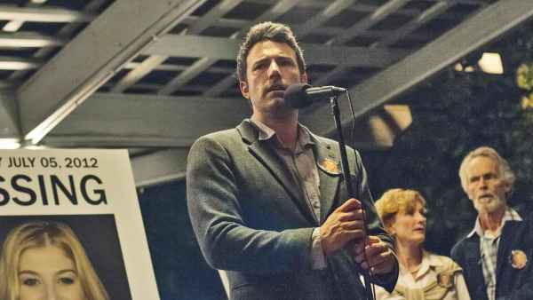 Rosamund Pike (in poster), Ben Affleck, Lisa Banes, David Clennon in Gone Girl