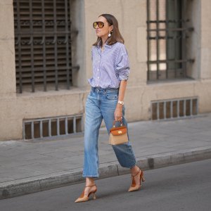 MUNICH, GERMANY - JUNE 8: Annette Weber is seen wearing a blue and white striped cotton oversized shirt with a loose silhouette from Glamometer x Seidensticker; light blue denim straight leg jeans with a cropped silhouette from Citizens of Humanity; brown suede pointed toe slingback shoes with a low heel from Rodo Firenze; a small brown and beige woven leather top handle bag with a compact silhouette, gold tone hardware and structured shape from Rodo Firenze; pearl drop earrings from Manuela Fumagalli, a rosé gold "Day Date Everose" wristwatch from Rolex; black nail polish; oversized oval acetate sunglasses with brown tinted lenses from Bottega Veneta; her brown hair is worn loose with a center part; with natural make up on June 8, 2026 in Munich, Germany. (Photo by Moritz Scholz/Getty Images)