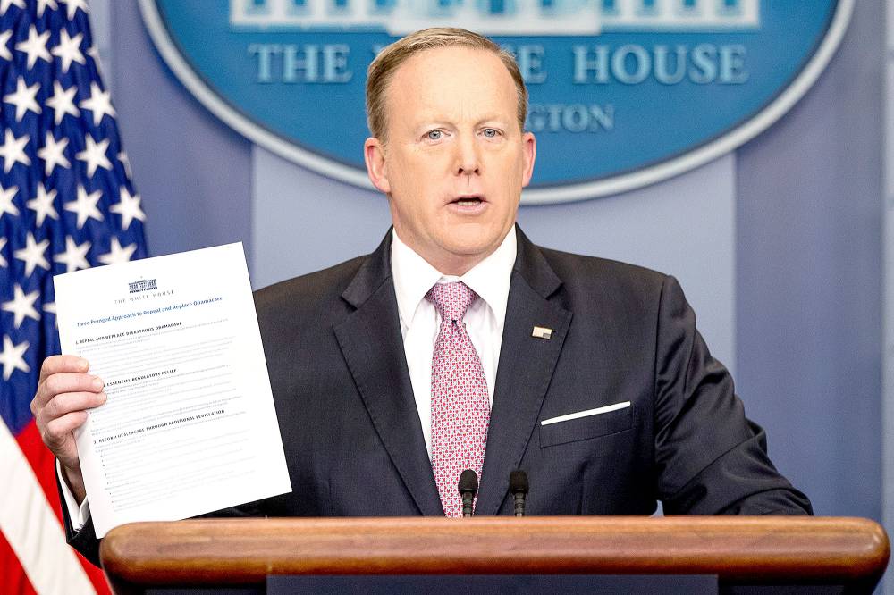 White House press secretary Sean Spicer holds up a Trump Administration document to "repeal and replace Obamacare" as he talks to the media during the daily press briefing at the White House in Washington, Friday, March 10, 2017.