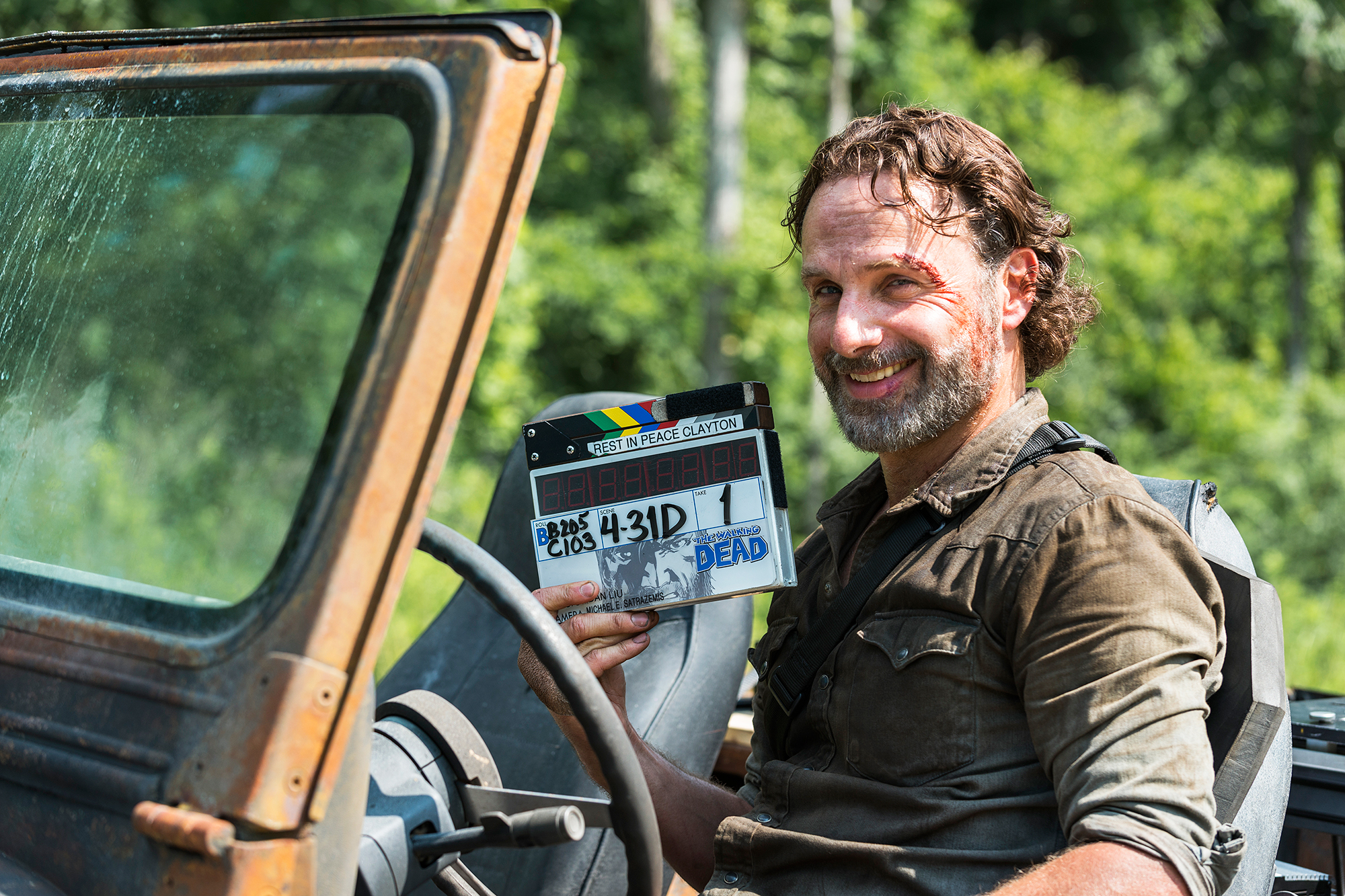 rick the walking dead smiling on a couch