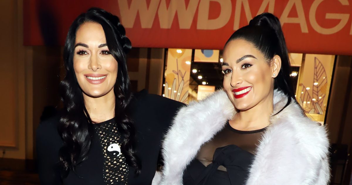 Nikki Bella touches her growing bump as she puts on loved-up