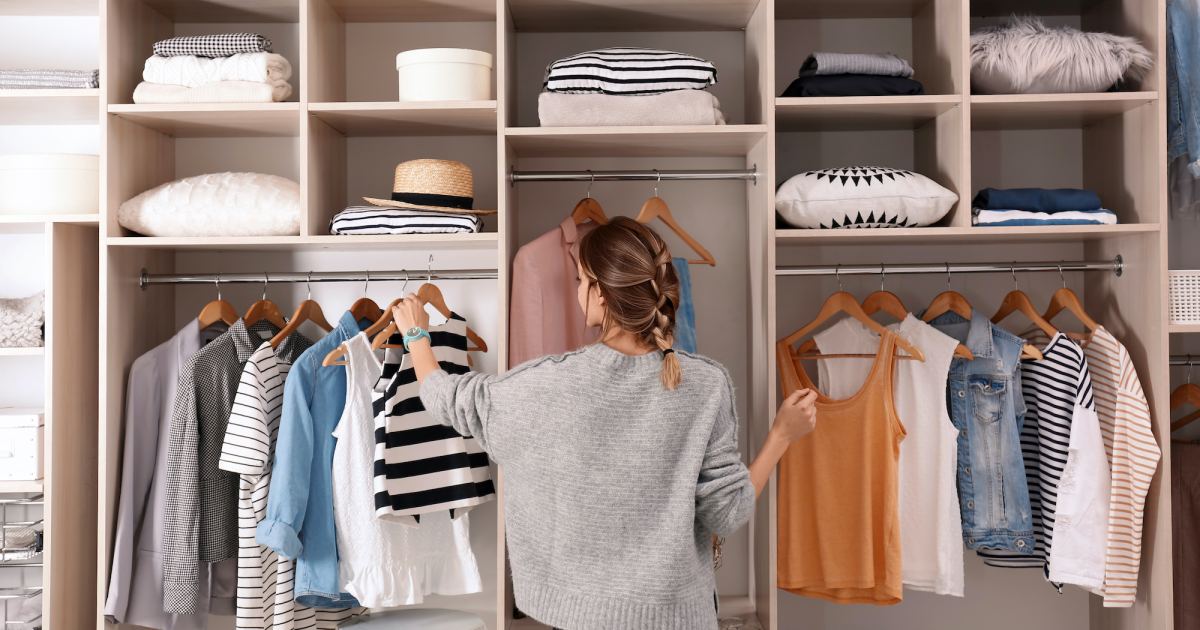 The interior of a fashion store of women's clothing of a famous brand. Mass  market. Brand clothes. All things are laid out neatly on the shelves in the  closet. Wardrobe order. Photos