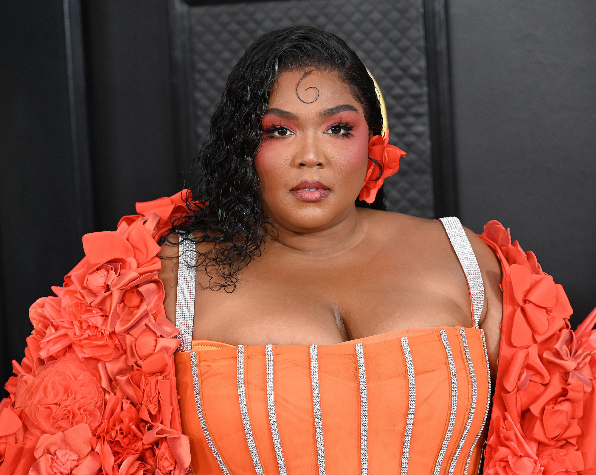 Lizzo looks peachy in corset, cape on Grammys 2023 red carpet