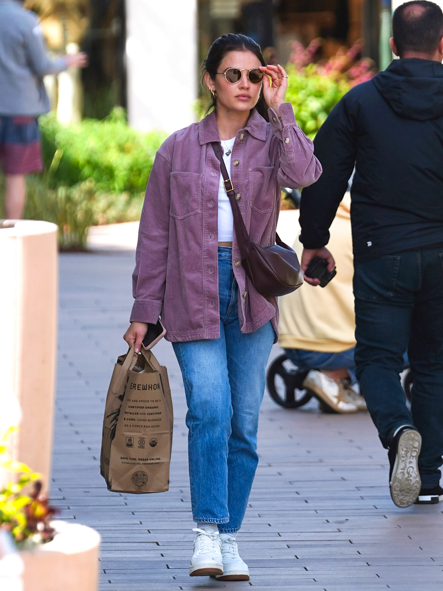 Lucy Hale looks cute in a crop top and jeans while she drops off a package