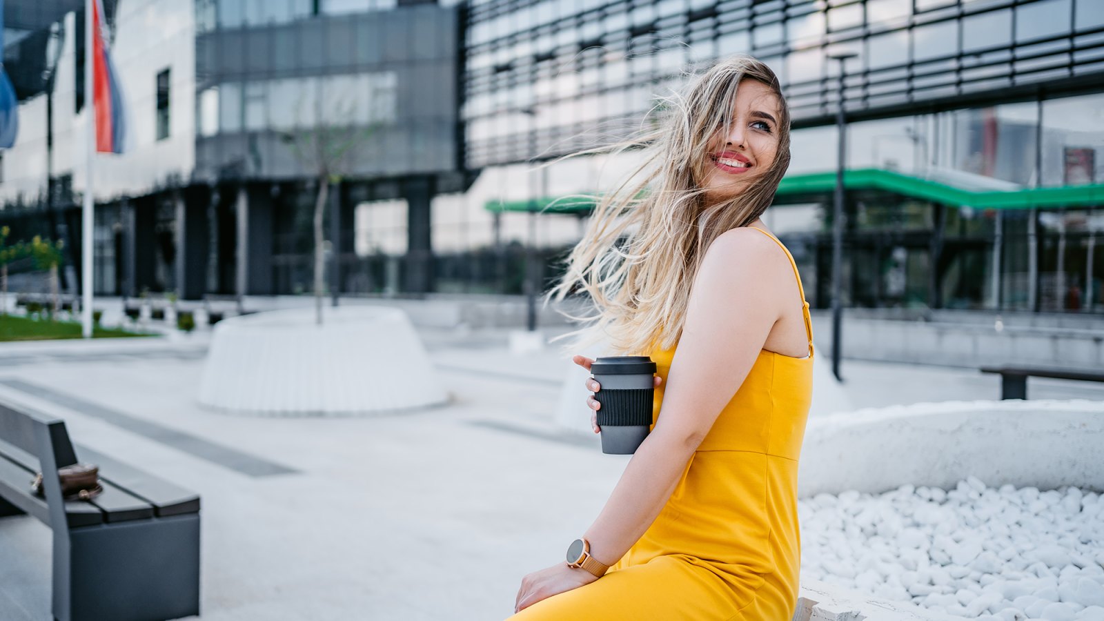 Beautiful young woman drinking coffee in a downtown district.