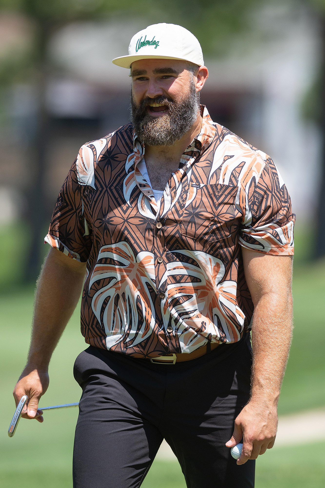 Jason Kelce gibt während eines Benefiz-Golfturniers ein Autogramm für den Strampler des weinenden Babys