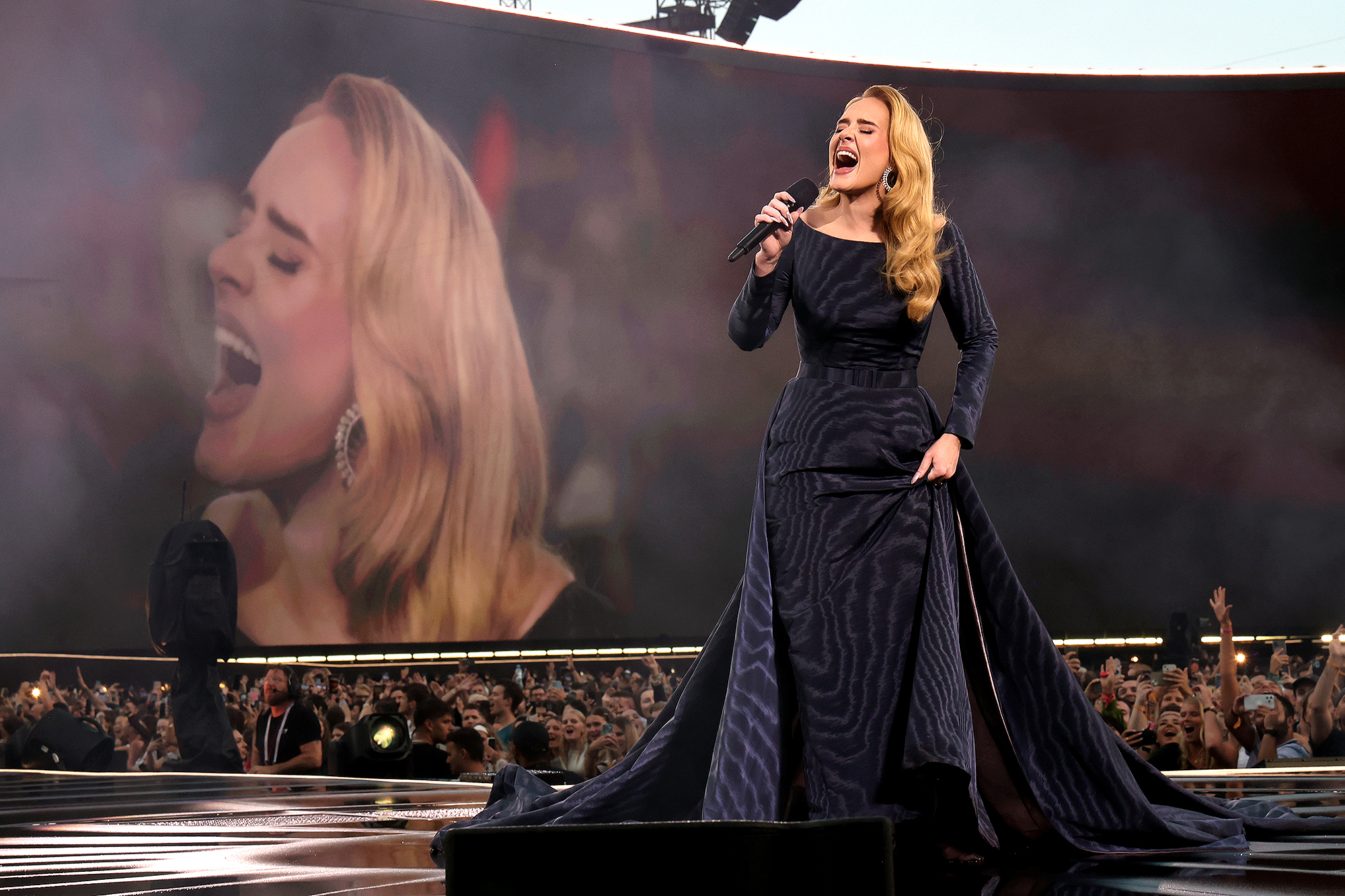 Adele scherzt über ihre New-Balance-Sneaker, während sie bei strömendem Regen auftritt