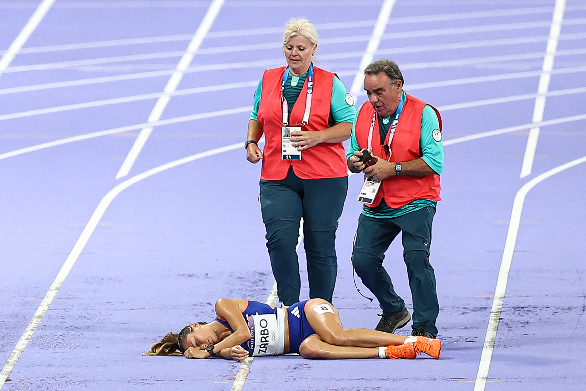 A atleta olímpica francesa Alessia Zarbo desmaia durante a corrida feminina de 10.000 metros