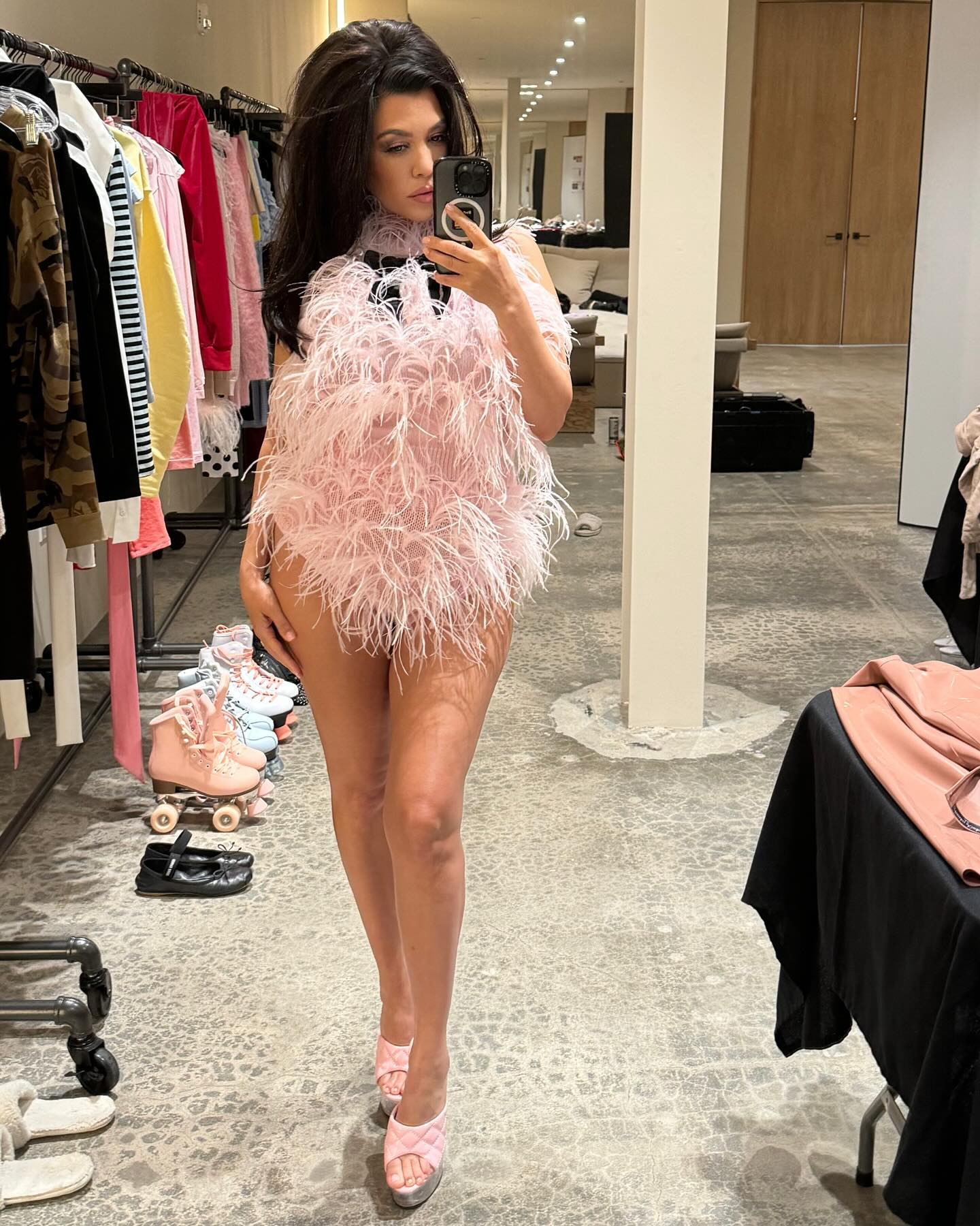 Kourtney Kardashian mostra as pernas em conjunto de penas combinando