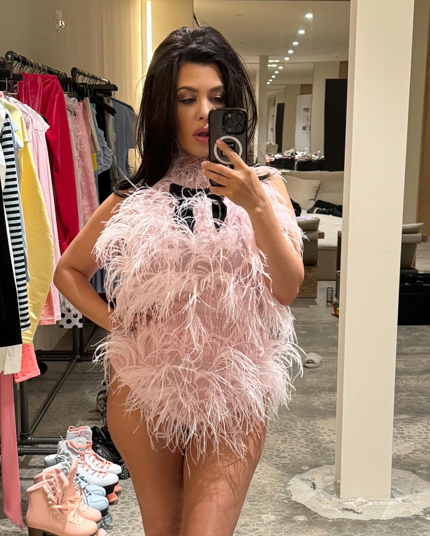 Kourtney Kardashian mostra as pernas em conjunto de penas combinando