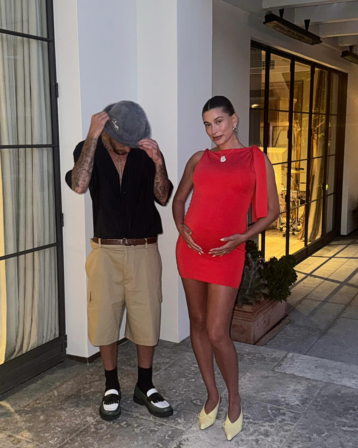 Pregnant Hailey Bieber Cradles Her Baby Bump in Ruby Frock With Justin