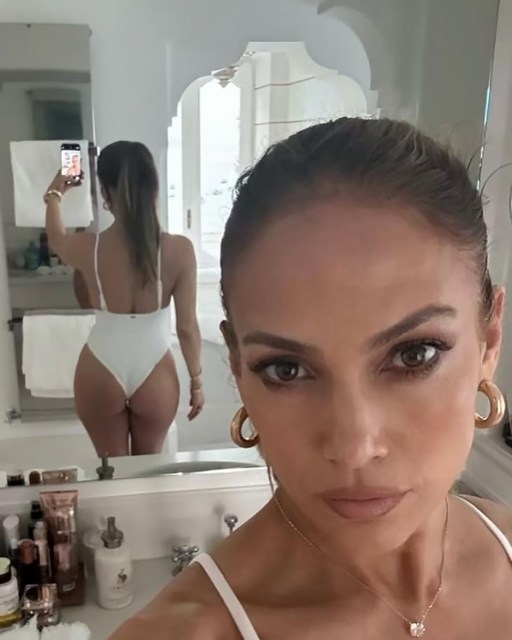 Jennifer Lopez exibe suas curvas em maiô branco de uma peça