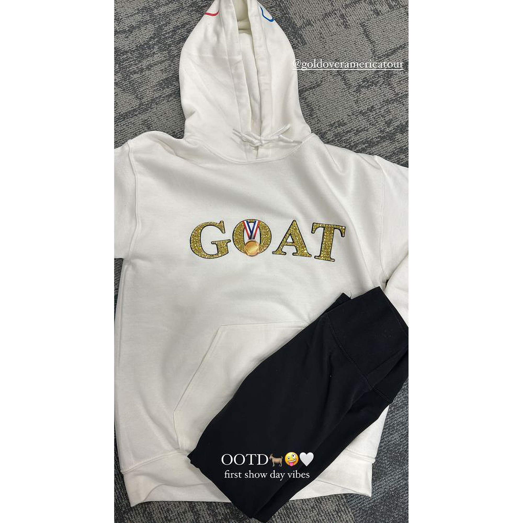 Simone Biles präsentiert auf der Gold Over America Tour ihr schillerndes GOAT-Sweatshirt